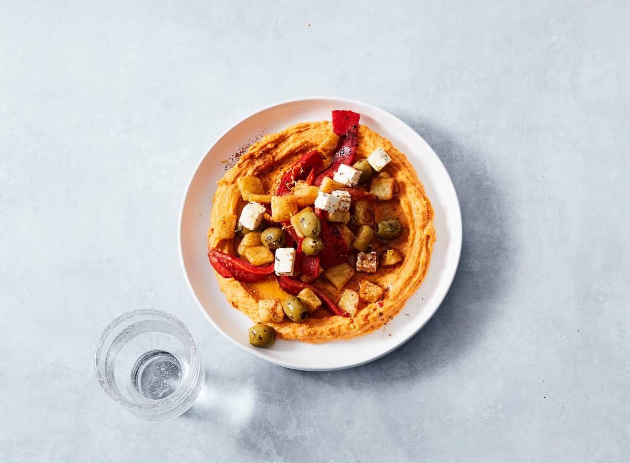 Pikante hummusbowl met aardappel en olijven