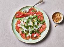 Deze vegetarische carpaccio maak je van gemarineerde watermeloen, pijnboompitjes en Parmezaan.