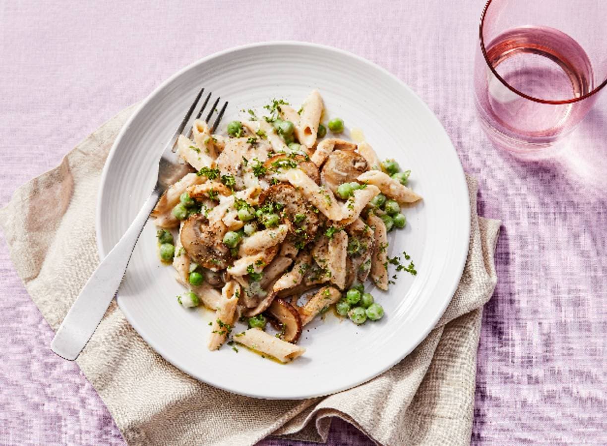 Pasta met champignonsaus, kip en tuinerwten