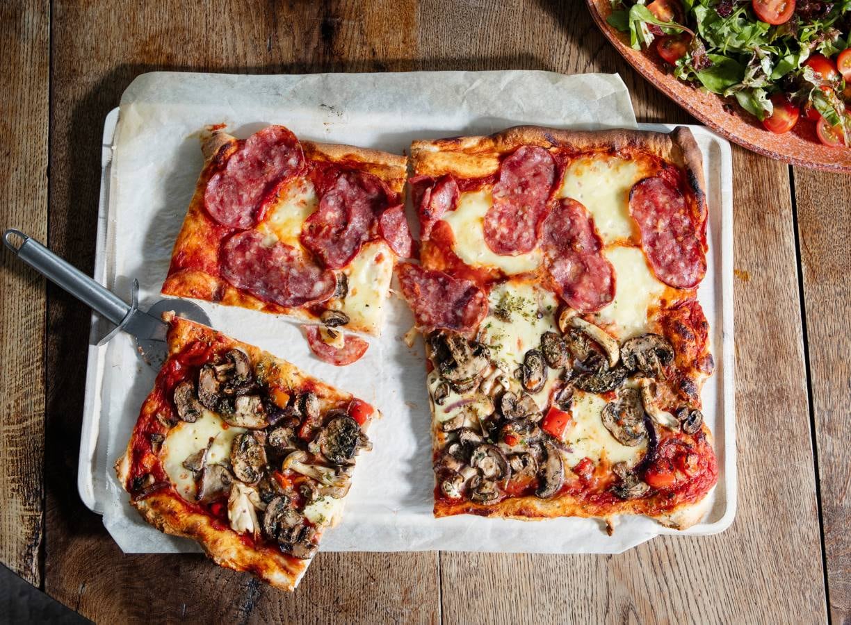 Pizza met mozzarella, paddenstoelen en salami
