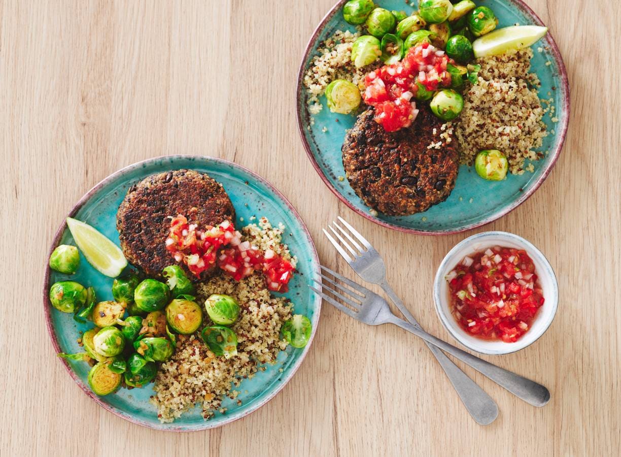 Zwarte-bonenburgers met pittige tomatensaus, quinoa en spruitjes