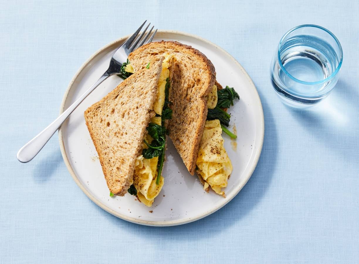 Gezonde sandwich met roerei en gebakken spinazie