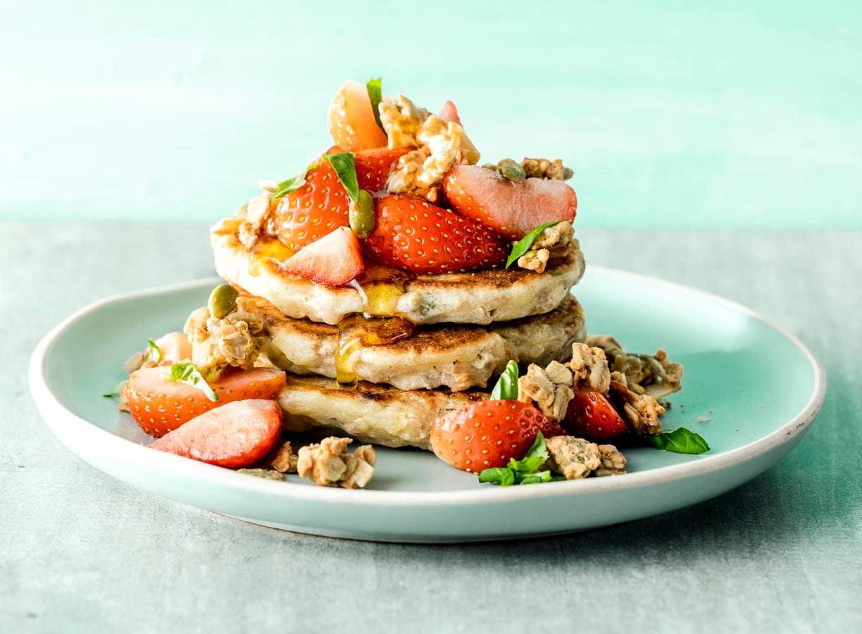 Glutenvrije granola-pancakes met aardbeien en basilicum