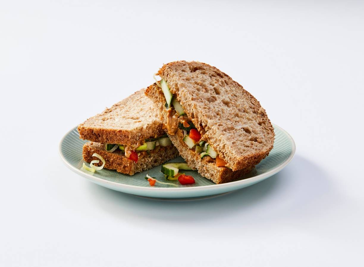 Volkorenbrood met pindakaas en rauwkost komkommer