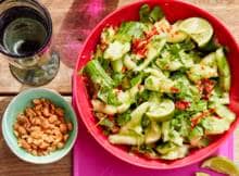 Kneus je komkommers, dan nemen ze alle smaken extra goed op. Zoals in deze salade met rode peper, limoen, vissaus, suikerpinda's en verse koriander.