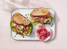 Met de snelle ingelegde rode ui en zelfgemaakte kikkererwtenspread barst deze sandwich van de smaken!