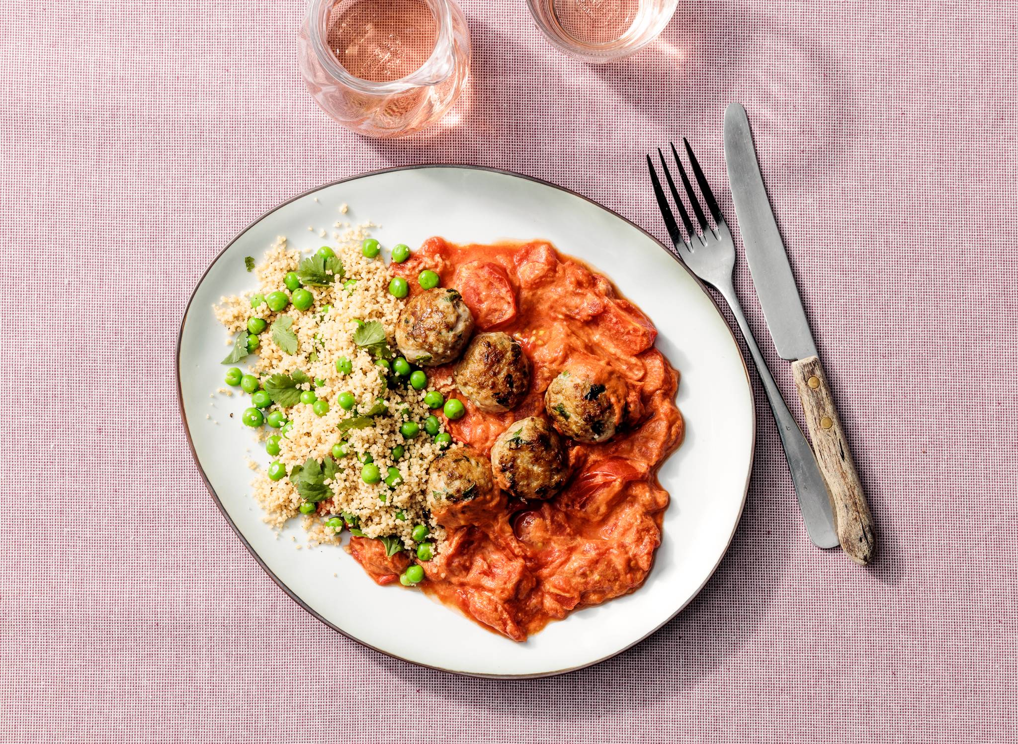 Kipgehaktballetjes in tomatentahinsaus met koriander en erwten
