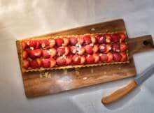 Deze zomerse aardbeientaart maak je met geroosterde amandelen en frangipane voor onweerstaanbare amandelsmaken.