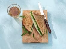 It's lunch time! Dus maken we een sandwich met zuivelspread kruiden, verse bieslook, rucola en komkommer. Zo snel, gezond, vegetarisch en budgetvriendelijk kan een goedgevulde boterham zijn.