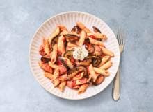 Pasta met aubergine in de tomatensaus: zo krijg je een flinke portie groente binnen. Dankzij een pepertje en ricotta romig en lichtpittig tegelijk. Aanschuiven!