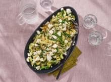 Welk seizoen het ook is: pastasalade kan altijd. Deze vega salade maak je met courgette, sperziebonen en witte kaas. 