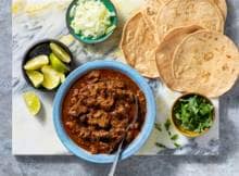 Een van de definities van barbacoa is: gestoofd vlees dat wordt gegeten met maistortilla's. In dit recept garneer je het langzaam gegaarde rundvlees in een taco met ui, koriander en limoenpartjes.