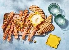 Fijne combi, gegrilde garnalenspiesjes van de BBQ met frisse mangosalsa. Fijn erbij: geroosterd brood met aioli. 