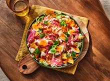 Warm, spicy en een beetje messy: deze nachos in een pittige saus maken van je borrel een feestje!