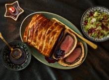 Verras je gasten met Beef Wellington: sappig rundvlees omhuld in krokant croissantdeeg voor een vleugje zoet, geserveerd met glühweinjus voor een warmte, luxe en feestelijke smaak.