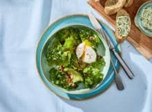 Salade met spekjes, gepocheerd ei en broodje kruidenboter